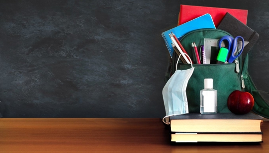 backpack filled with school supplies and a mask